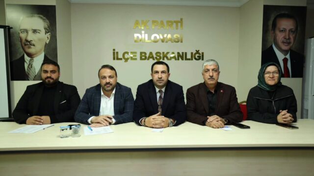 AK Parti Dilovası İlçe Başkanlığı yazısının önünde masada yan yana oturan dört erkek ve başörtülü bir kadın.