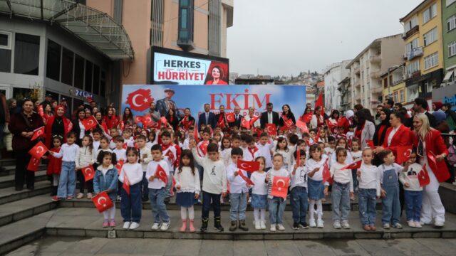 Merdivenlerde Türk bayrağı tutan çok sayıda çocuk ve yetişkin toplu halde poz veriyor.