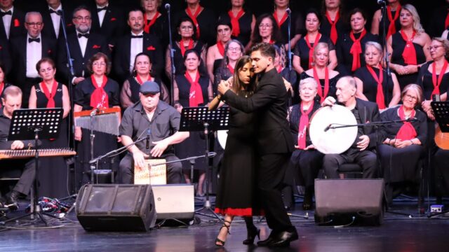 Koronun önünde siyah giysili bir çift sahnede tango yapıyor